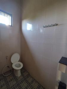 a bathroom with a white toilet and a window at OYO Life 92637 Kost Arya Exclusive in Jambi