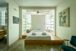 sypialnia z łóżkiem i dużym oknem w obiekcie Spacious & Green 3BR Apt w Balcony in City Center by Sea N' Rent w Tel Awiwie