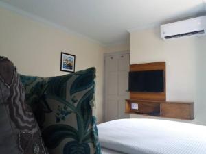 a hotel room with a bed and a television at Buccoo-B in Buccoo