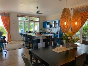 a kitchen with blue cabinets and a table with chairs at Villa Sealinks City Mui Ne 3br - SeaHome O867,7O7,123 in Phan Thiet