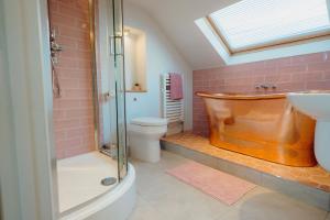 a bathroom with a tub and a toilet and a sink at Luxury sea-view apartment in Tenby - Floral Corner in Pembrokeshire