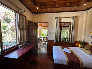 a bedroom with a bed and a large window at Ammata Boutique Villa in Luang Prabang