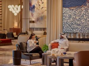 a woman and a man sitting in chairs in a lobby at Grand Hyatt Kuwait in Kuwait +82 photos