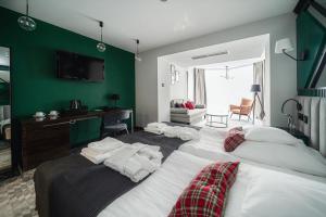 sypialnia z 2 łóżkami i zieloną ścianą w obiekcie Rysy Boutique Hotel w Zakopanem