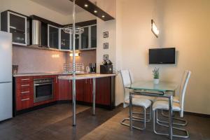 eine Küche mit einem Tisch und Stühlen sowie einem Kühlschrank in der Unterkunft MareliS Skies VIP Apartment in Topola