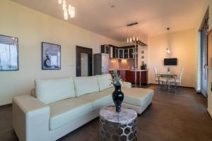 ein Wohnzimmer mit einem weißen Sofa und einem Tisch in der Unterkunft MareliS Skies VIP Apartment in Topola