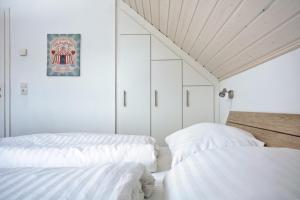 two beds in a room with white walls and ceilings at Blinkfüer - a88738 in Nordhorn