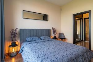 ein Schlafzimmer mit einem blauen Bett und einem Spiegel in der Unterkunft MareliS Skies VIP Apartment in Topola