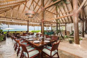 uma sala de jantar com uma mesa longa e cadeiras em CALETON 8 9 ACCESS TO EDEN ROC BEACH CLUB CHEF BUTLER MAiD GOLF CARTS POOLS JACUZZI em Punta Cana