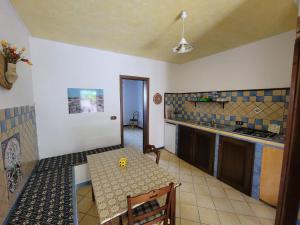 cocina con mesa, mesa pequeña, mesa y mesa en Mamalù en Lampedusa