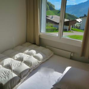 a room with two beds in front of a window at Casa Segnas in Disentis