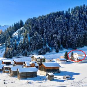 un piccolo villaggio nella neve con un cerchio rosso di Casa Segnas a Disentis