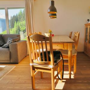 a dining room with a wooden table and chairs at Casa Segnas in Disentis