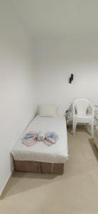a white bedroom with a bed and a chair at Nika Apartments in Ulcinj