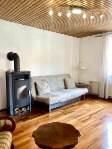 sala de estar con sofá y estufa de leña en Ferienwohnung am Tabor, en Bad Radkersburg
