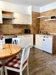 a kitchen with a wooden table and white cabinets at Ferienwohnung Spezerei in Bad Radkersburg +4 photos