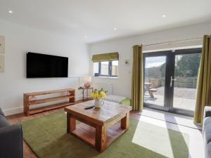 a living room with a tv and a coffee table at The Old Dairy in Canterbury