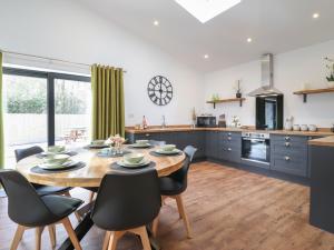 a kitchen and dining room with a wooden table and chairs at The Goose Shed in Canterbury