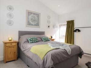 1 dormitorio con 1 cama con manta amarilla en The Goose Shed, en Canterbury