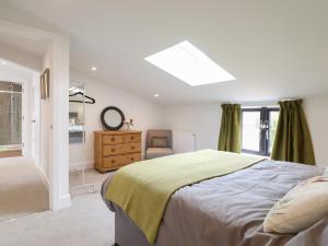 a bedroom with a bed and a dresser and a window at The Old Dairy in Canterbury