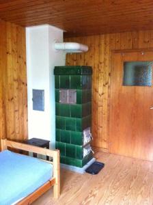 ザンクト・ペーターにあるEckhäusleのベッドと緑の暖炉が備わる部屋