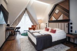 Schlafzimmer mit einem Bett, einem Schreibtisch und einem TV in der Unterkunft Rysy Boutique Hotel in Zakopane + 37 Fotos