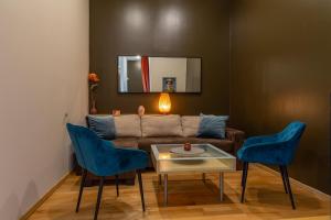 - un salon avec un canapé et deux fauteuils bleus dans l'établissement House of Frida, à Cracovie