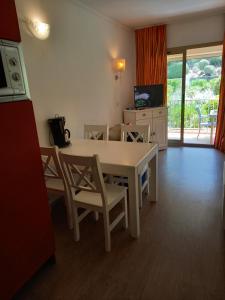 uma sala de estar com uma mesa branca e cadeiras em LE VALLON DU ROY em Sanary-sur-Mer