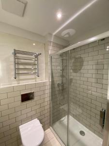 a bathroom with a shower and a toilet and a sink at Notting Hill House in London