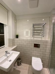 a bathroom with a white toilet and a sink at Notting Hill House in London