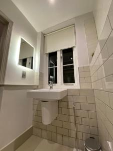 a bathroom with a sink and a window at Notting Hill House in London