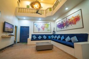 a living room with a blue couch and a tv at Slackpackr Hyderabad in Hyderabad