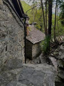 a stone building with a staircase leading to a house at Rustico Leoro in Ponte Brolla