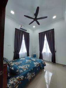 een slaapkamer met een bed en een plafondventilator bij Homestay2 Tok Bali in Pasir Puteh