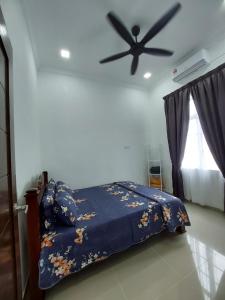 een slaapkamer met een bed en een plafondventilator bij Homestay2 Tok Bali in Pasir Puteh
