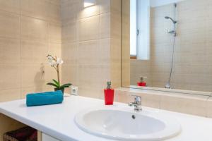 La salle de bains est pourvue d'un lavabo blanc et d'un miroir. dans l'établissement House of Frida, à Cracovie
