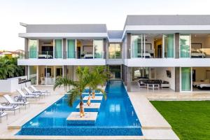 una casa con piscina frente a ella en VILLA PALMA ULTRA MODERN VILLA WITH CHEF BUTLER MAiD LAP POOL, en Punta Cana