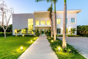 una casa con palmeras y luces delante de ella en VILLA PALMA ULTRA MODERN VILLA WITH CHEF BUTLER MAiD LAP POOL, en Punta Cana