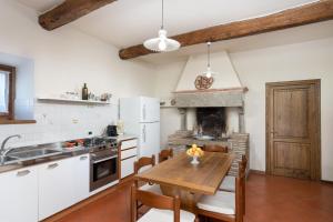cocina con mesa de madera y chimenea en Villa Il Mulino, en Calbenzano
