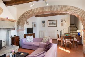 sala de estar con sofá púrpura y chimenea en Villa Il Mulino, en Calbenzano