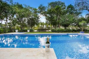 een zwembad met een fles wijn in een vaas bij VILLA LOS ENSUENOS NEAR BEACH AND GOLF POOL JACUZZI MAiD in Punta Cana