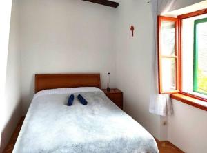 um quarto com uma cama com dois sapatos azuis em Guest house Ana em Drnis