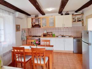 uma cozinha com uma mesa e cadeiras e um frigorífico em Guest house Ana em Drnis