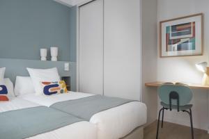 a bedroom with a white bed and a desk at Daira Arena by FeelFree Rentals in San Sebastián