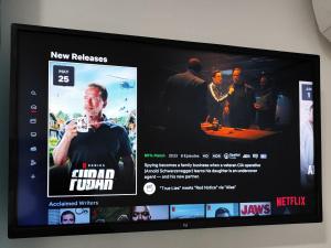 a television with a movie on the screen at Siempre Viva Dhermi in Dhërmi