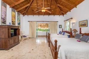 een slaapkamer met 2 bedden en een plafondventilator bij VILLA LOS ENSUENOS NEAR BEACH AND GOLF POOL JACUZZI MAiD in Punta Cana