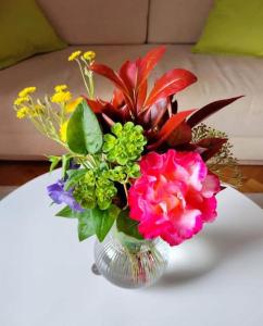 um vaso de vidro cheio de flores sobre uma mesa em Guest house Ana em Drnis