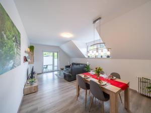 a dining room and living room with a table and chairs at Ferienwohnung am Spielberg in Freiamt