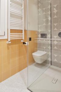 a bathroom with a toilet and a glass shower stall at Daira Arena by FeelFree Rentals in San Sebastián