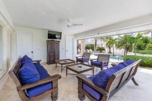 a living room with a blue couch and chairs at VILLA BLANCA CHEF BUTLER MAiD POOL JACUZZI NEAR THE BEACH in Punta Cana